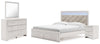 Cama King Altyra con almacenamiento, tocador, espejo y mesita de noche con paneles tapizados